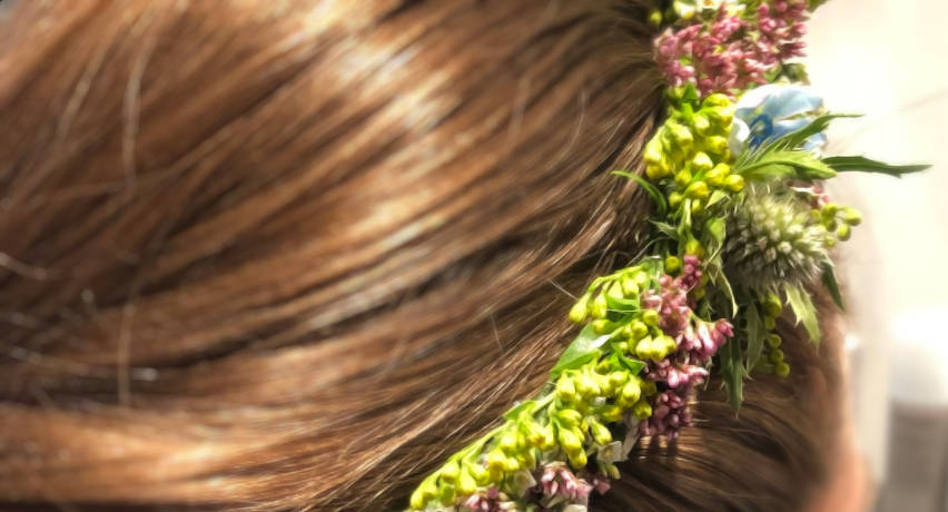 Brudeopsætning med blomsterkrans i fletning sidder foran spejlet